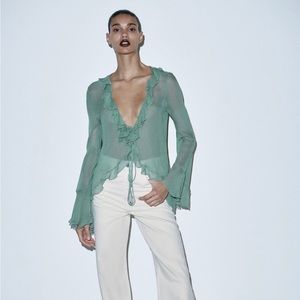 Ruffled sheer blouse with rosette